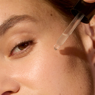 Woman applying serum with a dropper